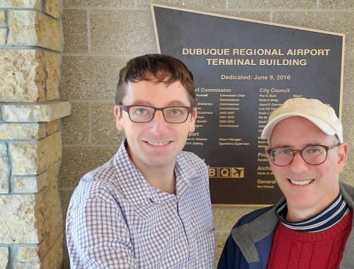 Engagious employees by Dubuque regional airport sign