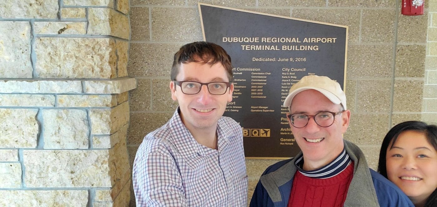 Engagious employees by Dubuque regional airport sign
